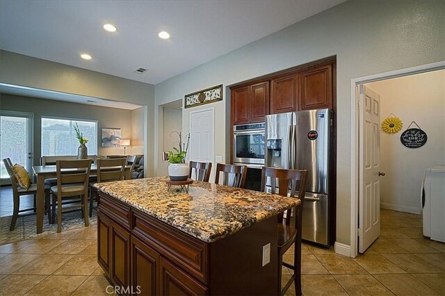 31961 Honeysuckle Cir, Winchester, CA 92596 - kitchen featuring stainless steel fridge with ice dispenser, a breakfast bar area, washer / clothes dryer, recessed lighting, and a center island