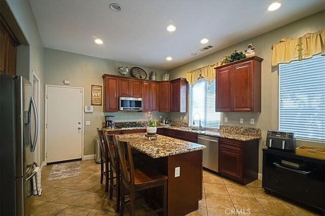 31961 Honeysuckle Cir, Winchester, CA 92596 - kitchen featuring appliances with stainless steel finishes, a sink, a breakfast bar, light tile patterned floors, and recessed lighting