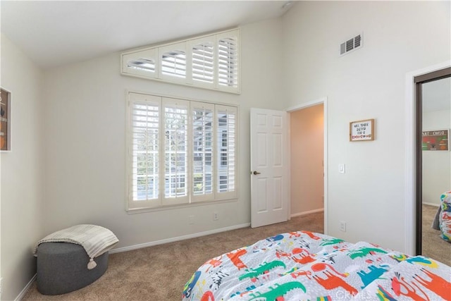 bedroom with visible vents, baseboards, a closet, a high ceiling, and carpet