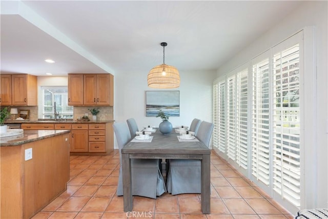 kitchen with backsplash, hanging light fixtures, light tile patterned floors, a sink, and recessed lighting