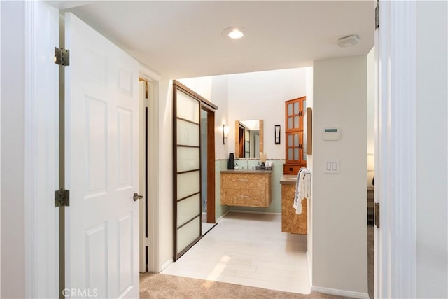 hallway featuring baseboards and recessed lighting