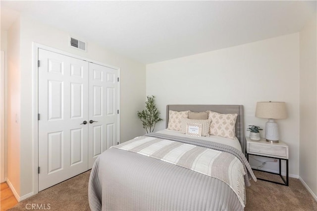 bedroom featuring baseboards, visible vents, carpet, and a closet