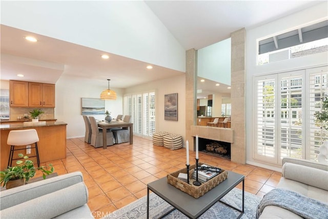 living area featuring recessed lighting, high vaulted ceiling, light tile patterned floors, and a wealth of natural light