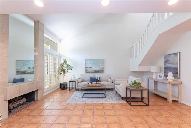 living area with high vaulted ceiling, recessed lighting, baseboards, light tile patterned floors, and stairway