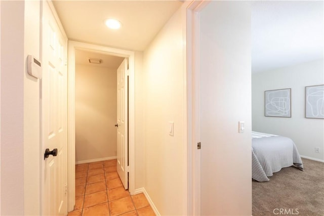 corridor with baseboards and light tile patterned flooring