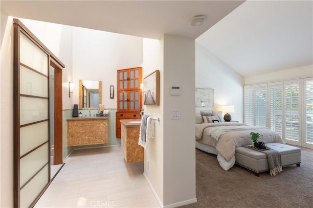 bedroom featuring baseboards and high vaulted ceiling
