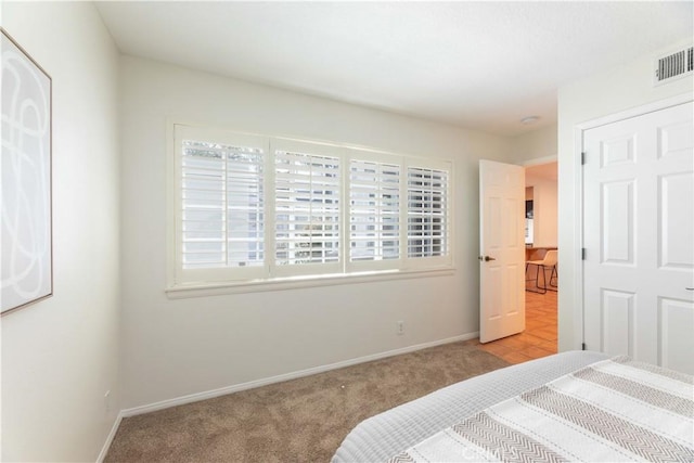 carpeted bedroom with baseboards and visible vents