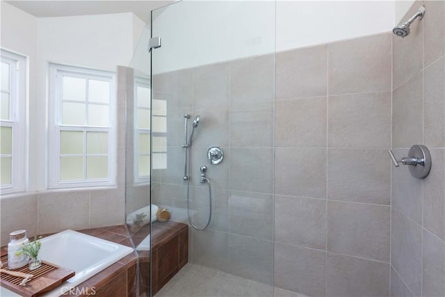 bathroom featuring a walk in shower and a bath
