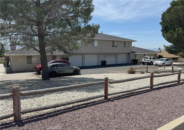 view of front facade with fence, driveway, and a garage