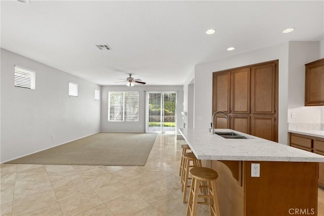 31937 Calle Galarza, Temecula, CA 92592 - kitchen featuring a sink, brown cabinetry, ceiling fan, an island with sink, and recessed lighting