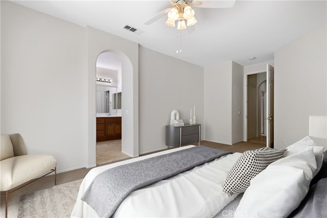 31937 Calle Galarza, Temecula, CA 92592 - bedroom featuring arched walkways, light carpet, ceiling fan, ensuite bathroom, and baseboards
