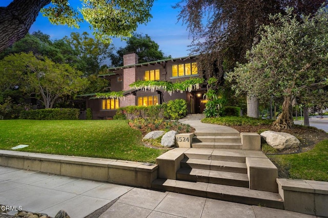 mediterranean / spanish home with a front yard and a chimney