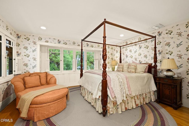 bedroom with visible vents, wood finished floors, wallpapered walls, ornamental molding, and recessed lighting