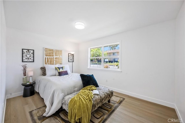 bedroom with baseboards and wood finished floors