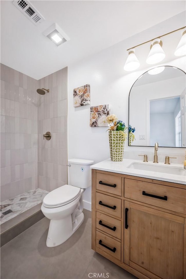 full bathroom with vanity, visible vents, toilet, and tiled shower