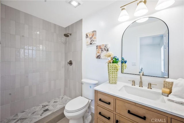 full bath featuring vanity, toilet, and tiled shower