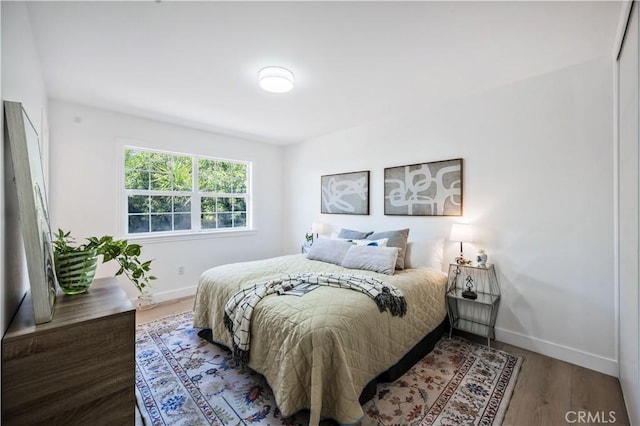 bedroom with baseboards and wood finished floors