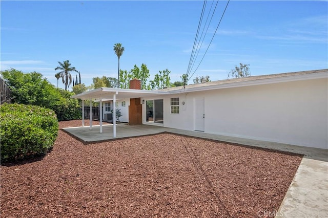 back of house with fence, a chimney, and a patio area