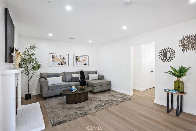 living room featuring recessed lighting, baseboards, visible vents, and wood finished floors