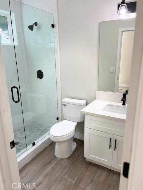 1861 S Redondo Blvd, Los Angeles, CA 90019 - full bath with vanity, wood finished floors, toilet, baseboards, and a shower stall