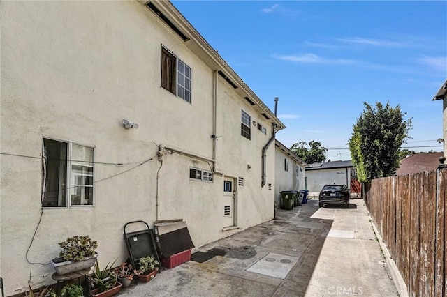 1861 S Redondo Blvd, Los Angeles, CA 90019 - view of side of home with fence, stucco siding, concrete driveway, and a patio area