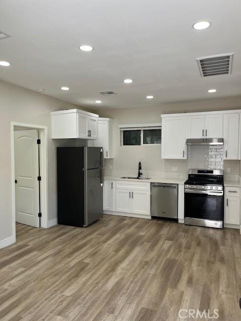 1861 S Redondo Blvd, Los Angeles, CA 90019 - kitchen featuring a sink, appliances with stainless steel finishes, wood finished floors, and visible vents
