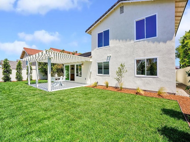 rear view of property with a lawn, a patio area, stucco siding, and a pergola