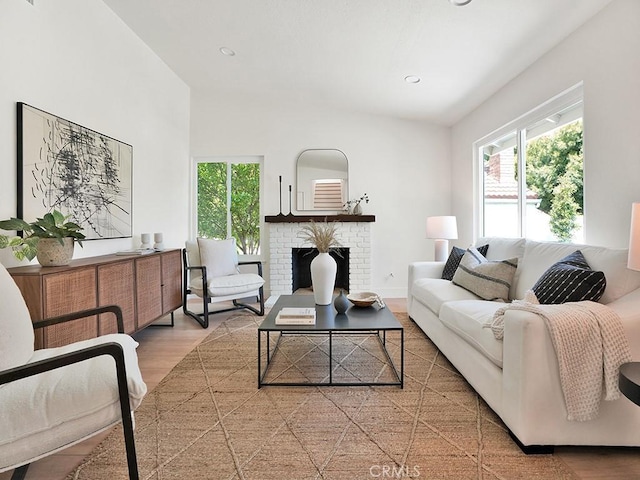 living area featuring plenty of natural light, a fireplace, recessed lighting, and wood finished floors