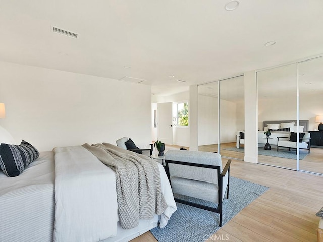 bedroom featuring two closets, light wood-style flooring, and visible vents