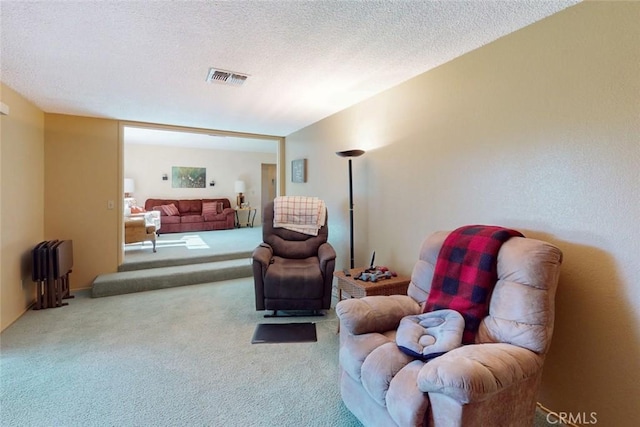 carpeted living area with a textured ceiling and visible vents