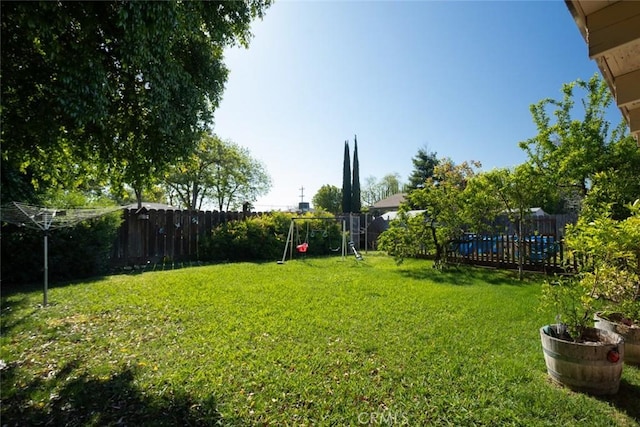 view of yard featuring a fenced backyard and a playground