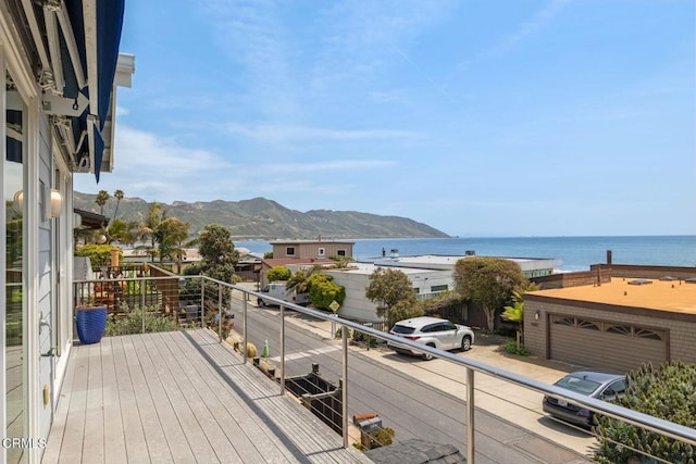 wooden terrace featuring a garage and a water and mountain view