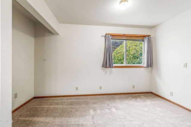 empty room featuring baseboards and carpet