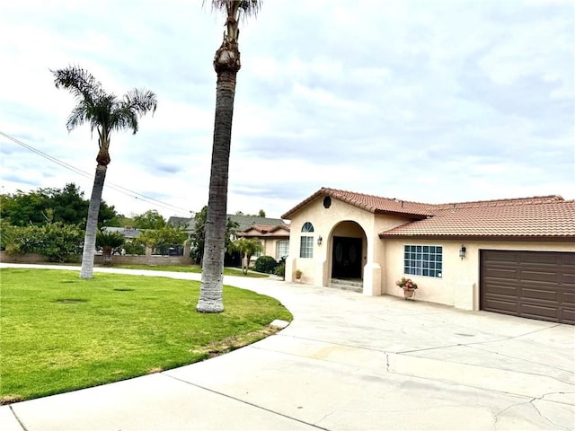 2285 W 2nd Ave, San Bernardino, CA 92407 - mediterranean / spanish home featuring concrete driveway, a garage, stucco siding, a tile roof, and a front yard