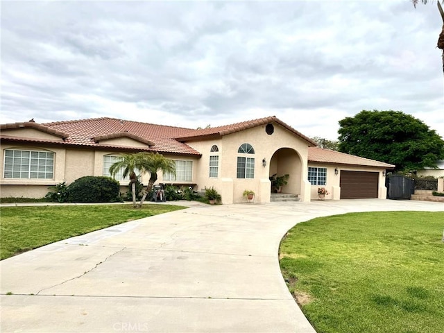 2285 W 2nd Ave, San Bernardino, CA 92407 - mediterranean / spanish-style home featuring driveway, stucco siding, a garage, and a front yard