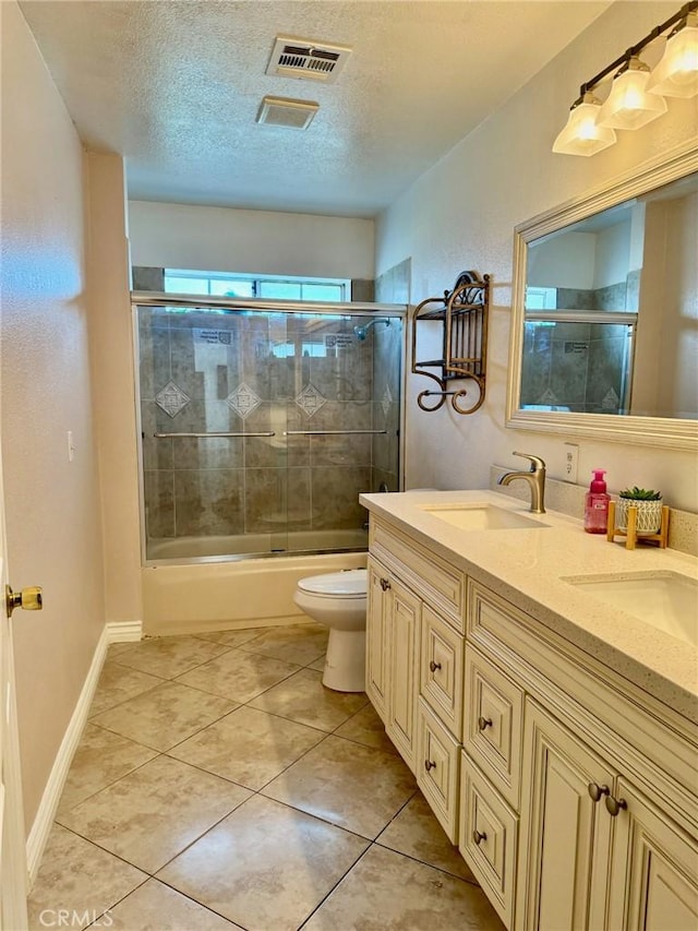 2285 W 2nd Ave, San Bernardino, CA 92407 - full bathroom featuring double vanity, a textured ceiling, tile patterned flooring, enclosed tub / shower combo, and toilet