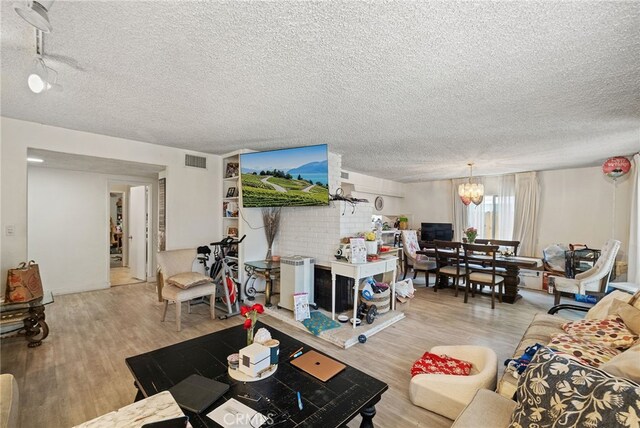 10139 Hayvenhurst Ave, North Hills, CA 91343 - living area featuring a textured ceiling, light wood-style floors, and a chandelier