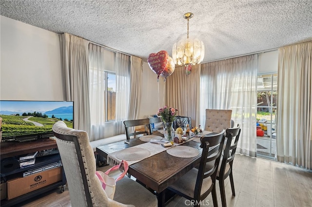 10139 Hayvenhurst Ave, North Hills, CA 91343 - dining space with a chandelier, a textured ceiling, and wood finished floors