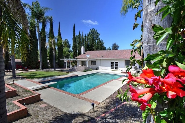 pool featuring a diving board and a patio area
