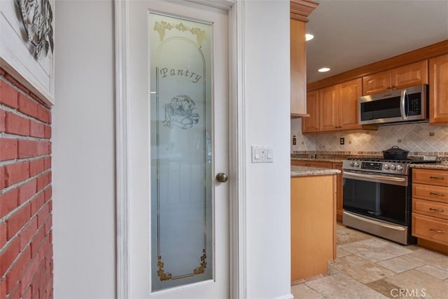kitchen with decorative backsplash, stone finish floor, recessed lighting, light stone counters, and stainless steel appliances