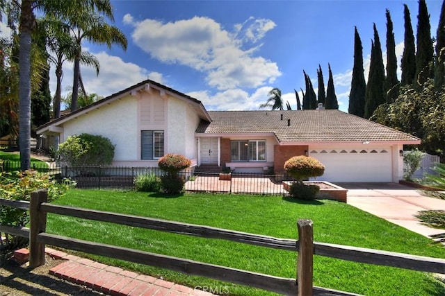 ranch-style home featuring an attached garage, a fenced front yard, and stucco siding