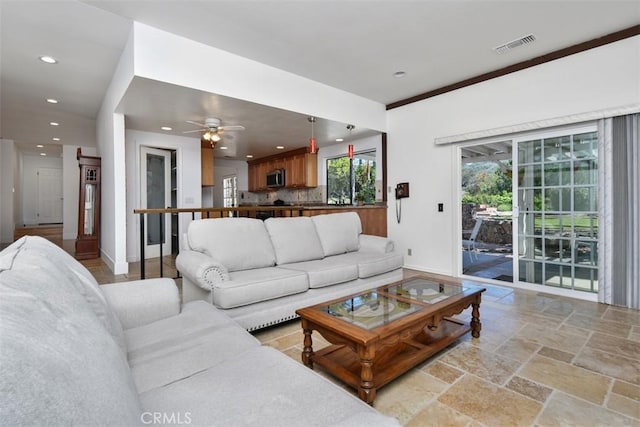 living area with stone tile floors, recessed lighting, baseboards, a ceiling fan, and visible vents