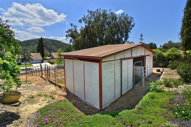 view of outbuilding with an exterior structure, a mountain view, and an outdoor structure
