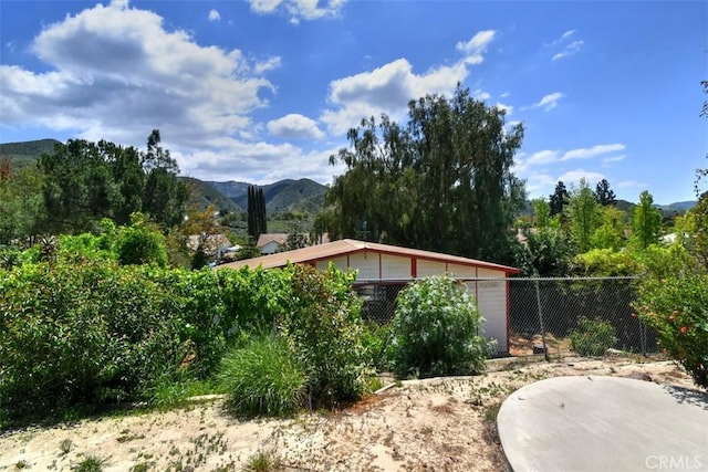 view of yard featuring fence and a mountain view