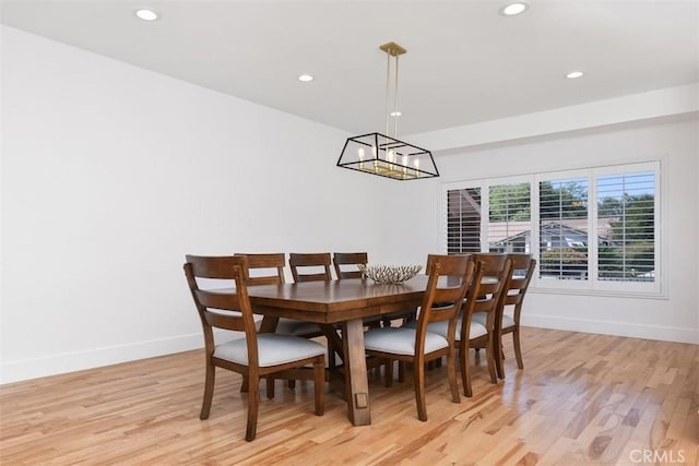 dining area with light wood-style floors, baseboards, recessed lighting, and a notable chandelier