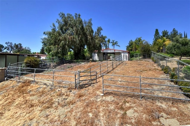 view of yard with an outbuilding, an exterior structure, and a rural view