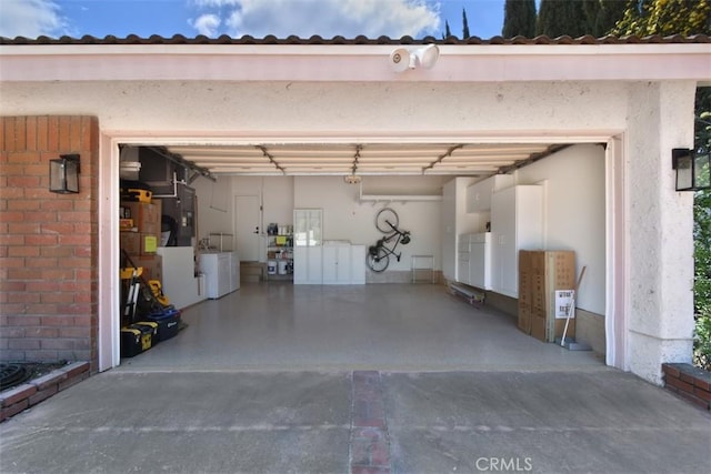 garage featuring independent washer and dryer and driveway