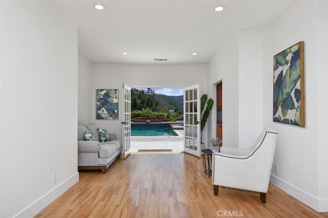 living area with recessed lighting, baseboards, light wood finished floors, and visible vents