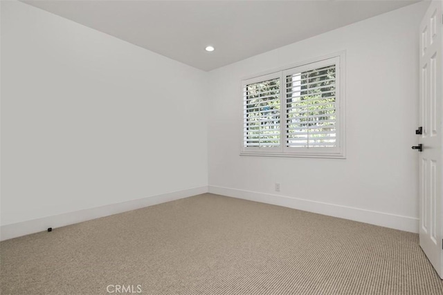 unfurnished room with recessed lighting, baseboards, and light carpet