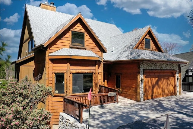 1305 Montreal Dr, Lake Arrowhead, CA 92352 - view of front facade with a garage, driveway, a shingled roof, and a chimney